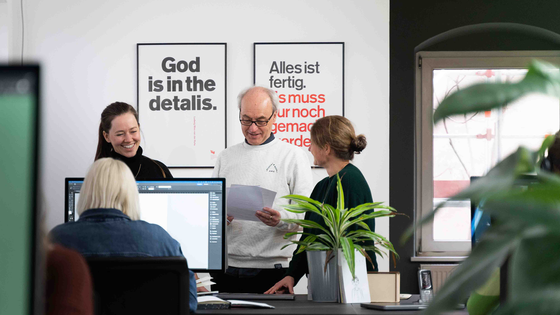 VISUELL Studio: 97a: Mitarbeiter stehen in einem Kreis und besprechen