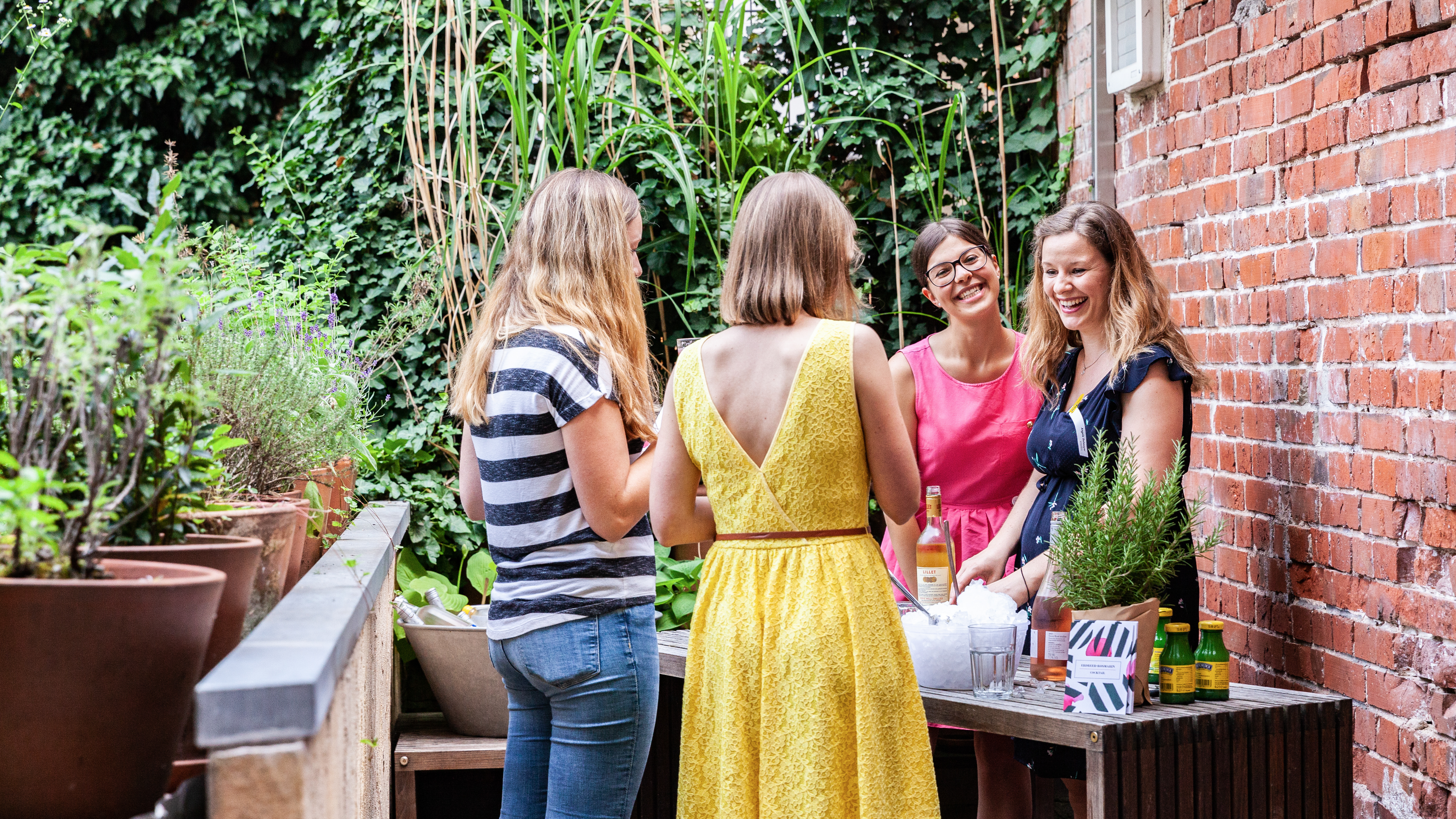 VISUELL Blogbeitrag: Event unterm Dach– das Olivenöl-tasting: Vier Frauen stehen im Hinterhof von VISUELL und unterhalten sich