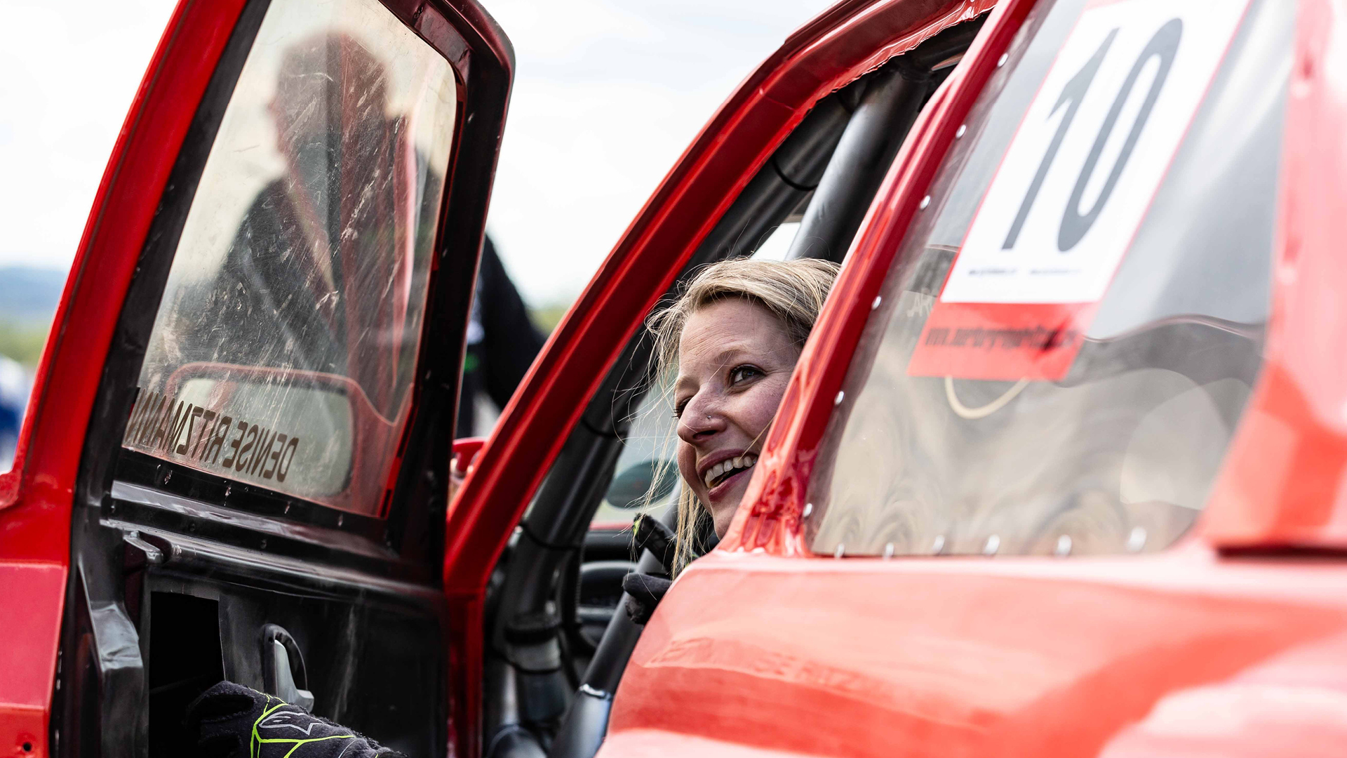 VISUELL Blogbeitrag: Titelstory des DeinsMeinsUnsers: Denise Ritzmann schaut aus dem Fenster ihres roten Autos