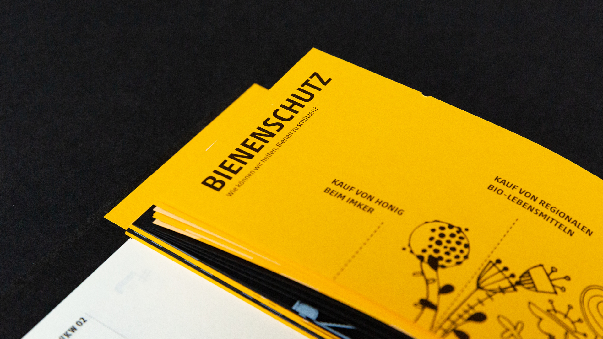 VISUELL Blogbeitrag: VISUELL-Kalender 2020: Aufteilung des Kalenderbuchs in gelbe Seite mit schwarzen Illustrationen und einer weiße Seite in der anderen Hälfte