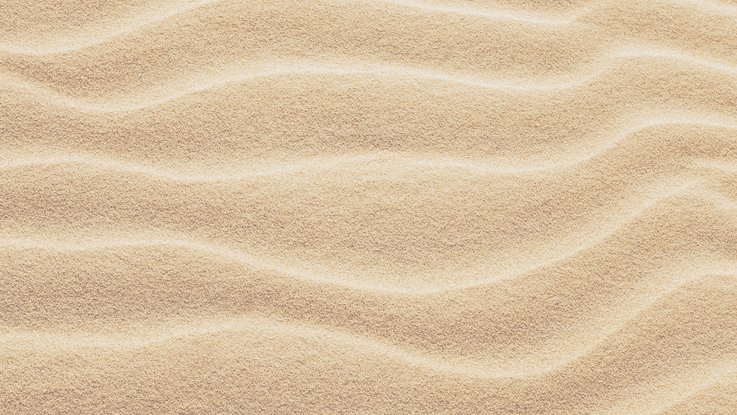 VISUELL Kommunikationsdesign: Corporate Design: Detailaufnahme eines Sandstrandes, leichtes Wellenmuster mit Licht- und Schattenspiel.