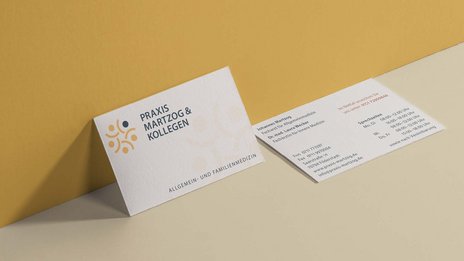 VISUELL Kommunikationsdesign: Corporate Design: Vorder- und Rückseite der Visitenkarte für die Praxis mit Wort-Bild-Marke in gelb und blau sowie Schrift in blau und rot auf cremefarbenem Naturpapier