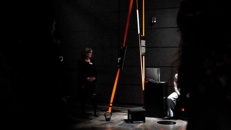 VISUELL Szenografie: Sonderausstellung: Anti Anti 2.0: Einzelne Station mit Kettlebell und Band; die physische Gewichtung übersetzt gesellschaftliche Verantwortung in eine greifbare Dimension.