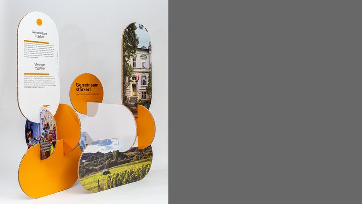 VISUELL Szenografie: Wanderausstellung „Common Grounds – Über Grenzen mitgestalten“ für die Robert Bosch Stiftung GmbH VISUELL Szenografie: Wanderausstellung Robert Bosch Stiftung GmbH: Gesamtansicht einer kompakten Modulgruppe mit abgerundeten Stelen, Text- und Bildflächen; die organische Formsprache verbindet Information und Bildwelten zu einer Einheit.