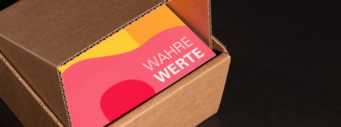VISUELL Kommunikationsdesign: Aufgeklappter Karton mit Blick auf die farbige Denkmalplakette des Landesamts für Denkmalpflege mit dem Schriftzug „Wahre Werte“