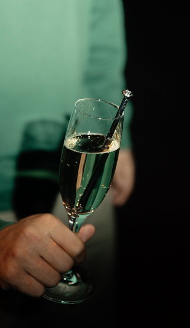 VISUELL Blogbeitrag: ADC Talent Festival 2025 „Goldenes Konfetti – Silberner Nagel“ VISUELL Blogbeitrag: ADC Talent Award 2025: Champagnerglas mit silbernem Nagel als Symbol für die Auszeichnung beim ADC Festival, Detailaufnahme im festlichen Rahmen.