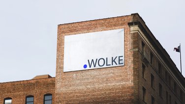 VISUELL Kommunikationsdesign: Corporate Design punktWOLKE: großer Banner mit dem Logo von punktWOLKE auf einem Backsteingebäude