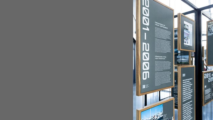 VISUELL Szenografie: Jubiläumsausstellung: Informationstafeln mit weißer Schrift auf anthrazitfarbenem Grund.