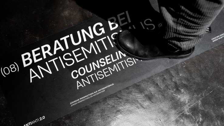 VISUELL Szenografie: Sonderausstellung: Anti Anti 2.0: Bodenbeschriftung zum Thema Beratung bei Antisemitismus; Informationsangebote verknüpfen Ausstellung mit gesellschaftlicher Praxis.