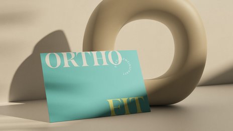 VISUELL Kommunikationsdesign: Corporate Design: Vorderseite der Visitenkarte für die Praxis mit Wortmarke in gelb/beige auf türkisfarbenem Naturpapier, beigefarbener Hintergrund mit Licht- und Schattenspiel.