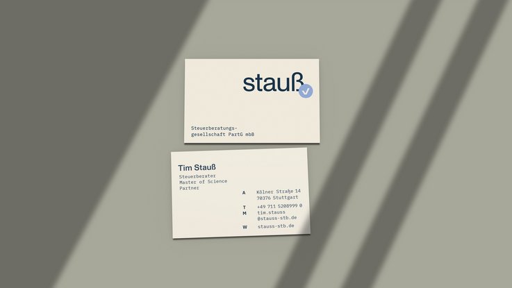 VISUELL Kommunikationsdesign: Corporate Design Stauß: Zwei Visitenkarten mit dem neuen Erscheinungsbild für Strauß Steuerberatung; gezeigt werden Wortmarke, Signet mit Häkchen, klare Typografie und eine reduzierte Farbwelt in Beige, Blau und Graugrün.