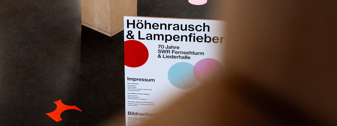 Szenografie: Jubiläumsausstellung: 70 Jahre Fernsehturm und Liederhalle: Titelmotiv der Ausstellung „Höhenrausch und Lampenfieber“ mit typografischem Keyvisual und farbigen Konfettipunkten als verbindendes Gestaltungselement der Jubiläumsinszenierung.