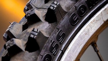 VISUELL Szenografie: Ausstellung: Detailaufnahme eines grobstolligen Reifens; die gezielte Lichtführung betont Materialität und Struktur.