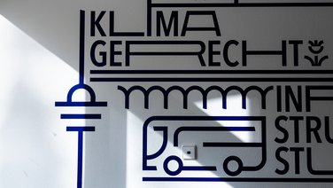 VISUELL Kommunikationsdesign: Wandgrafiken Landeshauptstadt Stuttgart: Typografisches Detail mit dem Begriff Klimagerecht und grafischen Linien, durch Licht und Schatten akzentuiert.