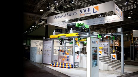 VISUELL Szenografie: Messestand STAHL CraneSystems: Gesamteindruck des offenen, einladenden Messestands, auf dem alle ausgestellten Hebezeuge bedient werden können