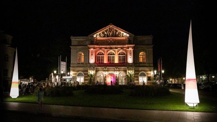 VISUELL Szenografie: Nacht des offenen Denkmals: Die Liederhalle in Baden-Baden angeleuchtet bei Nacht mit Leuchtkegeln und Banner ausgestattet