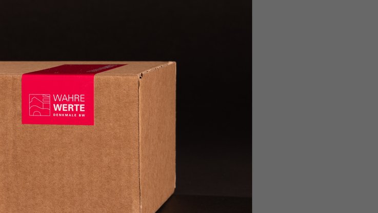 VISUELL Kommunikationsdesign: Detailaufnahme des Karton der Denkmalplakette des Landesamts für Denkmalpflege mit pinkem Verpackungssiegel „Wahre Werte“