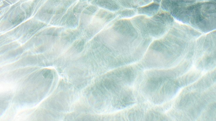 VISUELL Kommunikationsdesign: Corporate Design: Detailaufnahme einer Wasseroberfläche, zarte hellblaue Farbe und Reflexionen.