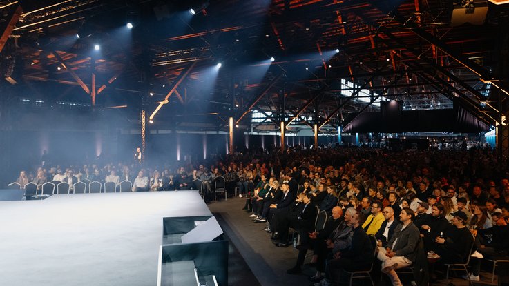 VISUELL Blogbeitrag: ADC Talent Festival 2025 „Goldenes Konfetti – Silberner Nagel“ VISUELL Blogbeitrag: ADC Talent Award 2025: Publikum in der Festivalhalle während der Preisverleihung, große Zuschauermenge unter stimmungsvoller Licht- und Bühnengestaltung.