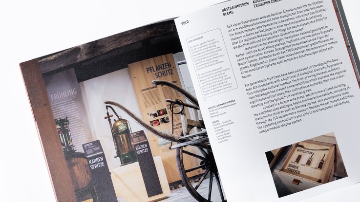 VISUELL Blogbeitrag: VISUELL gewinnt den FOCUS OPEN 2024 Gold für das Obstbaumuseum Glems VISUELL Blogbeitrag: FOCUS OPEN Award 2024 Gold: Eine Doppelseite aus dem Jahrbuch zum FOCUS OPEN Award 2024 mit vollflächigem Foto aus dem Obstbaumuseum auf der linken Seite und Text auf der rechten Seite.