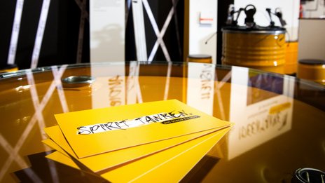 VISUELL Szenografie: Messestand Ideentanke MFG: Detailaufnahme von vier gelben Flyern mit der Aufschrift Spirit tanken