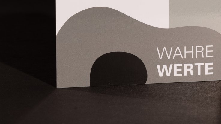 VISUELL Kommunikationsdesign: Detailaufnahme der Denkmalplakette in Graustufen des Landesamts für Denkmalpflege mit dem Schriftzug „Wahre Werte“