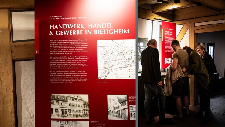 VISUELL Scenography: Permanent exhibition at Hornmoldhaus: Two-part view of an exhibition area on the theme of "Crafts, Trade & Industry in Bietigheim". On the left, a large-format red information board with a map and historical photographs; on the right, a group of visitors at an interactive station in the historic half-timbered room.