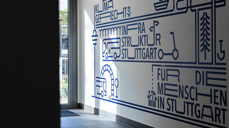 VISUELL Kommunikationsdesign: Wandgrafiken Landeshauptstadt Stuttgart: Wandgrafik im Flurbereich mit abstrahierten Infrastruktur-Icons wie Fahrzeugen, Brücken und Leitungen in klarer Linienführung.