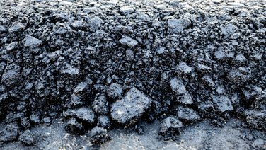 VISUELL Scenography: Straßen.NRW stand at InfraTech 2026: close-up of a rough asphalt surface; the materiality illustrates the core theme of road construction