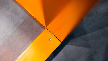 VISUELL Scenography: Straßen.NRW stand at InfraTech 2026: Close-up of a joint between the orange, powder-coated aluminium frames.