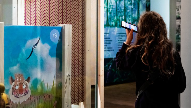 VISUELL Szenografie: Ausstellung „Spurensuche“: Besucher hört den Audio-Guide über das Handy