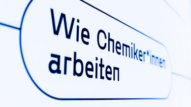 VISUELL Szenografie: Wissenschaftsausstellung: Nahaufnahme einer Beschriftung „Wie Chemiker*innen arbeiten“ in dunkelblauer Schrift auf weißem Hintergrund in der Wissenschaftsausstellung „Was kann Katalyse?“.